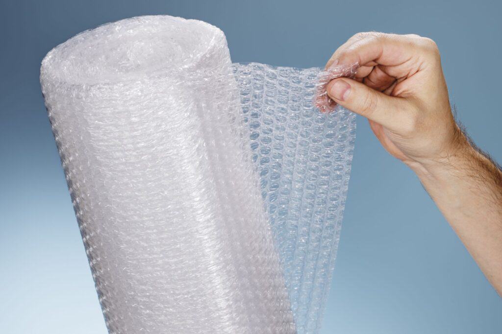 A closeup of a bubble wrap and a man's hand