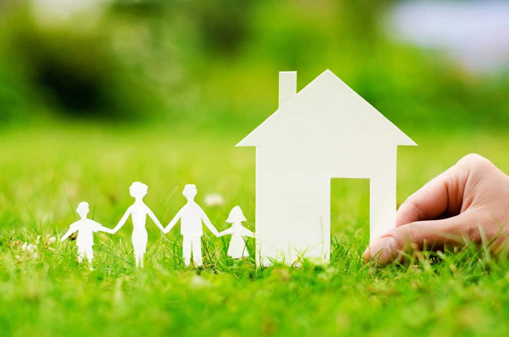 An illustration of a family and a house, cut cardboard