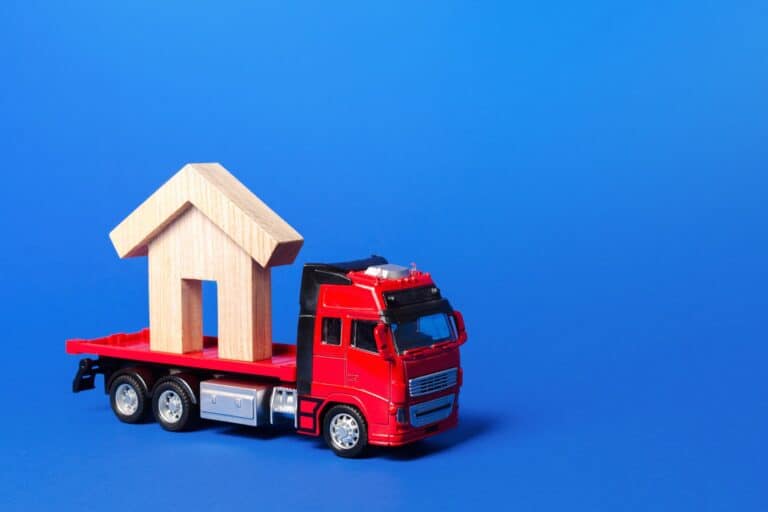 A red truck carrier toy with a house figure