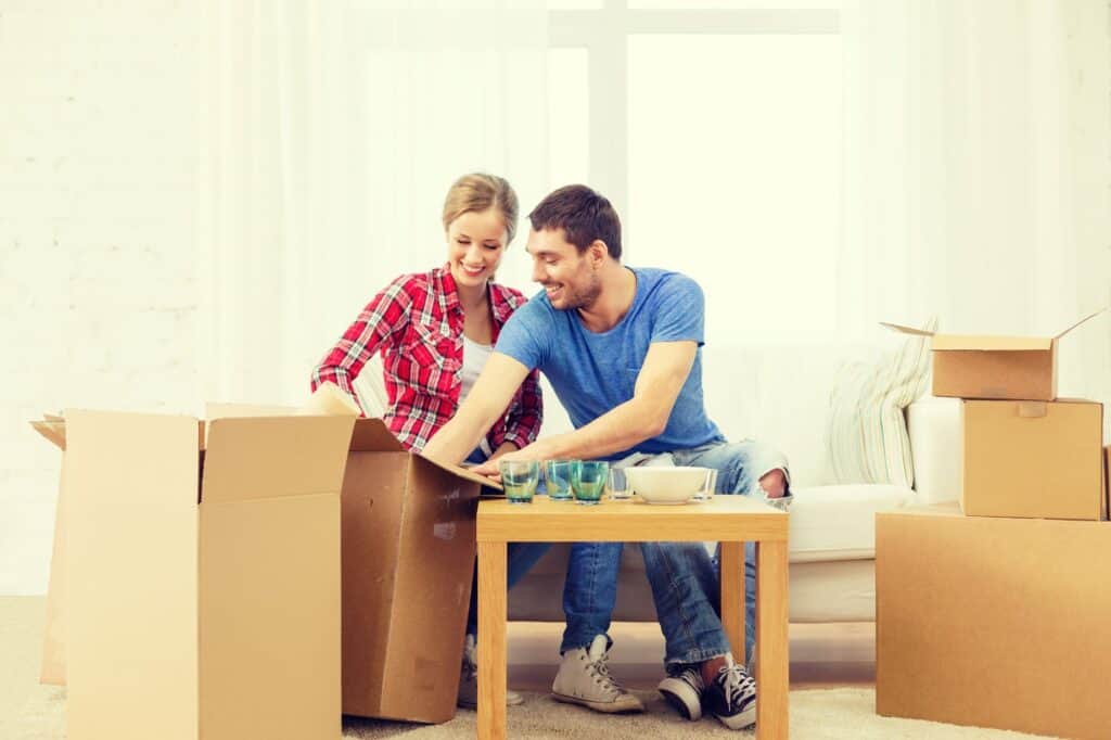 A smiling couple packing kitchenware
