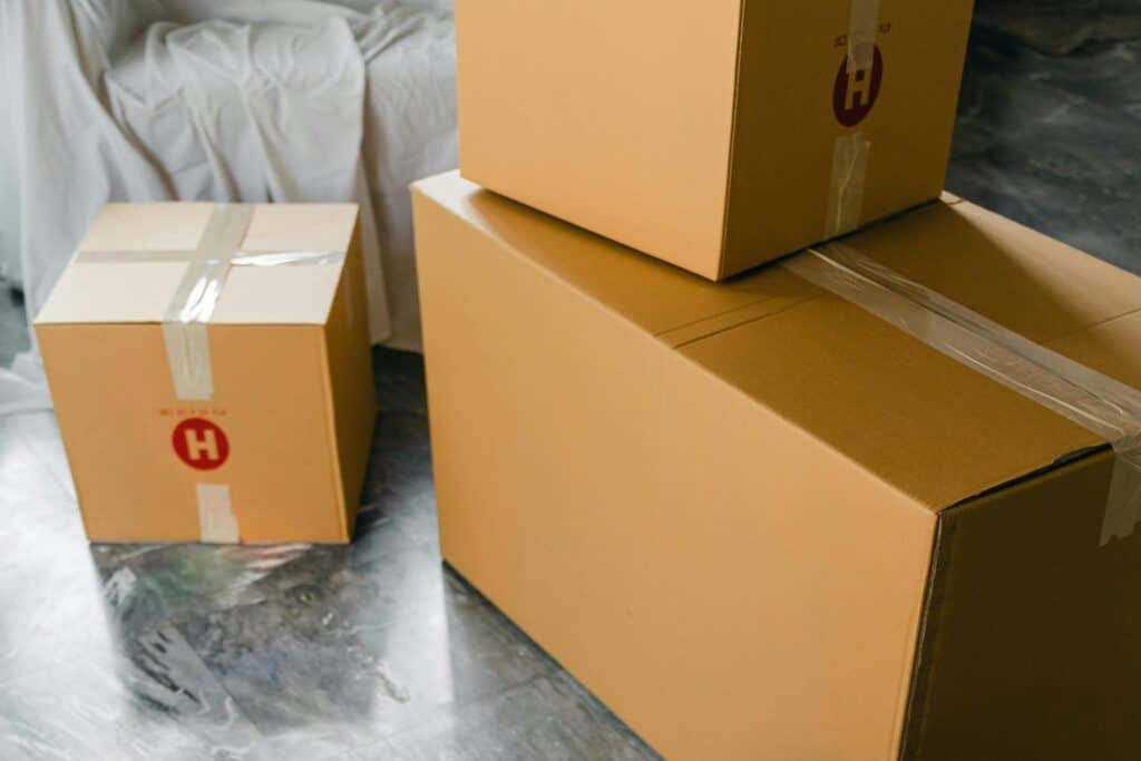 Packed boxes and wrapped sofa in the concept of moving to Harrow