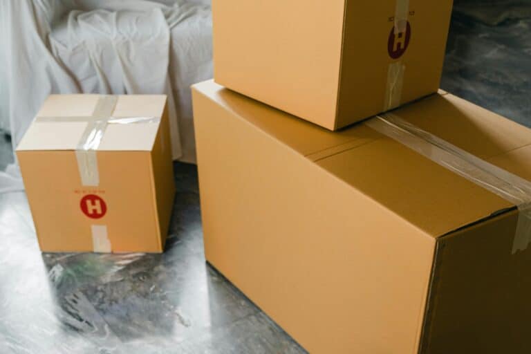 Packed boxes and wrapped sofa in the concept of moving to Harrow