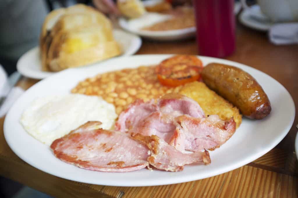 Traditional English breakfast, egg, bacon, sausage and beans served in a restaurant
