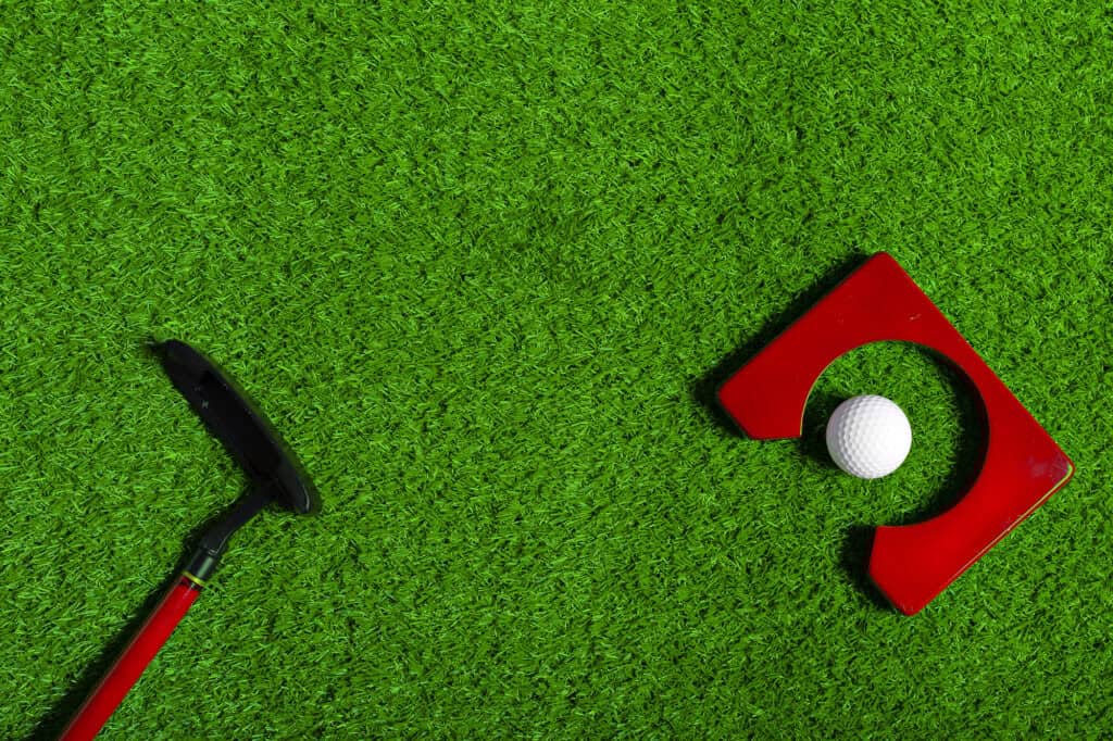 golf ball and golf club on grass